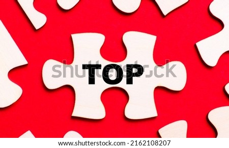 On a bright red background, white puzzles. In one of the pieces of the puzzle, the text TOP