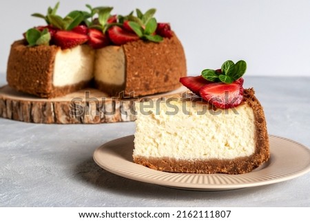 New York cheesecake is a dessert that is an open pie or even a cake. Decorated with strawberries. It consists of two main parts: sand base and cheese filling. Royalty-Free Stock Photo #2162111807
