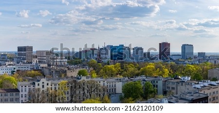 A panoramic picture of several rooftops and buildings of Łódź.