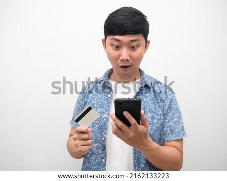 Asian man with credit card looking at mobile phone feel excted Royalty-Free Stock Photo #2162133223