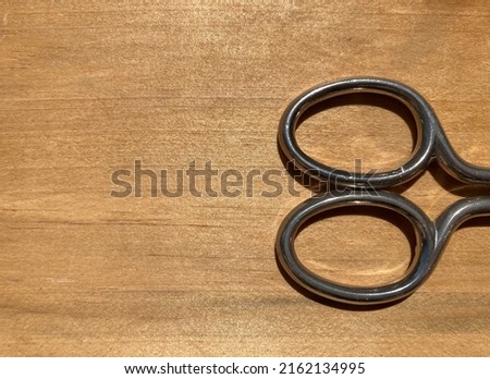 handle of metal scissors on a wooden surface