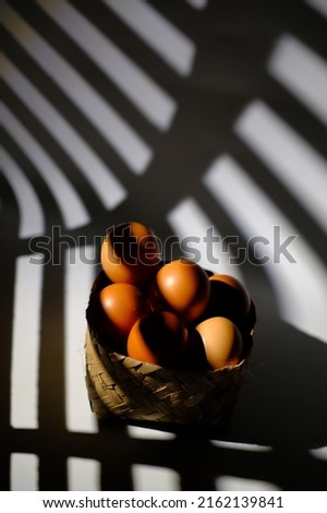 Eggs in a bamboo basket, in the shade of the window curtain