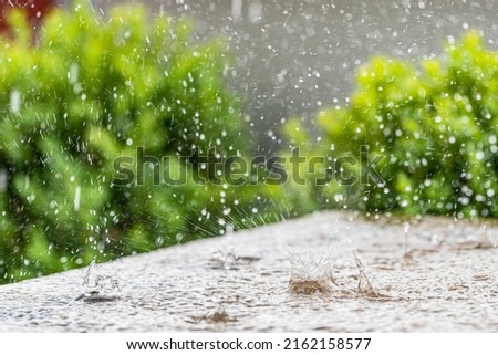 Heavy rain on a sunny summer day. Summer thunderstorms on the terrace stone table Royalty-Free Stock Photo #2162158577