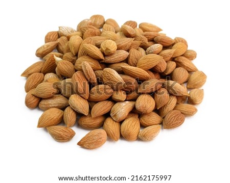 Brown apricot kernels on a white background. Dry apricot kernel close-up. Royalty-Free Stock Photo #2162175997