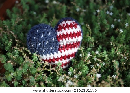 Crochet American flag heart plush. Isolated closeup. Hand knit Memorial Day design. 