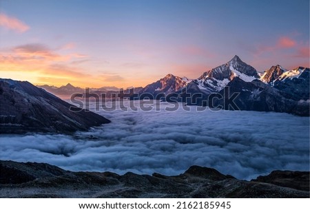 Mountain peaks in the fog at dawn. Foggy mountains at dawn. Beautiful sunrise in foggy mountains. Mountain morning fog at dawn Royalty-Free Stock Photo #2162185945