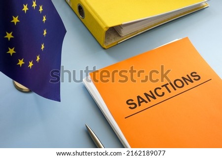 EU flag and sanctions list with a folder. Royalty-Free Stock Photo #2162189077
