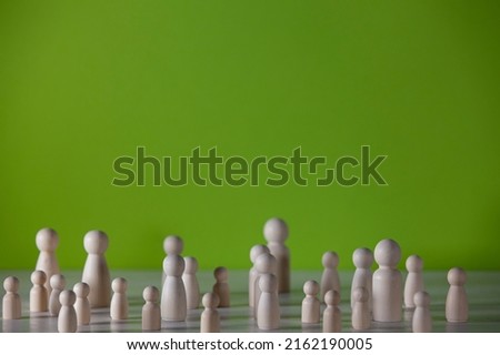 Wooden figures in the form of people on a colored background representing a social concentration