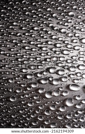 Abstract background with drops of water on polished iron metal flat surface