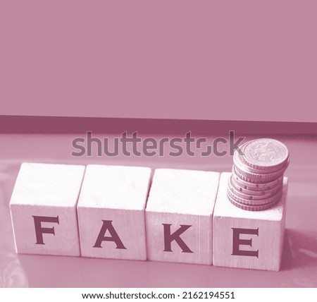 FAKE word written in wooden blocks on brown paper.