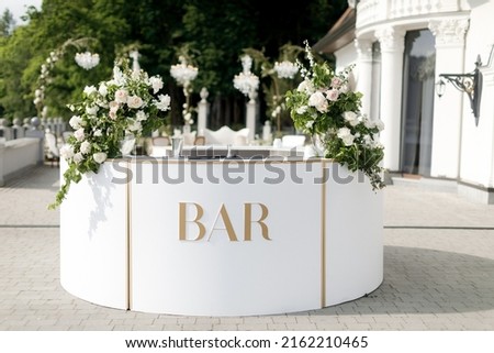 Bar counter decorated with flowers at a wedding party. Royalty-Free Stock Photo #2162210465