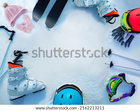 Many different items ski boots, helmets, masks poles gloves in the snow view from above