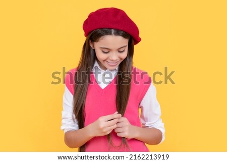 beautiful hair. happy french teen girl on yellow background. childhood happiness.
