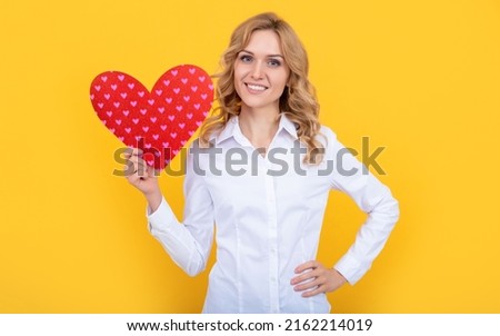 happy woman with red love heart on yellow background. donation