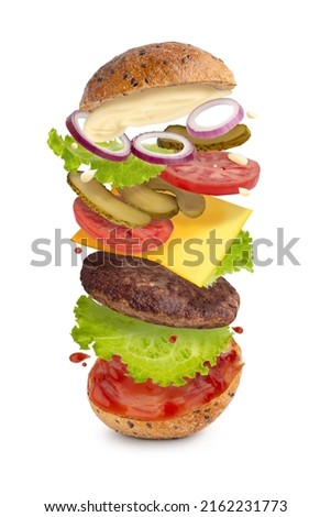 levitating burger with beef and vegetables on a white isolated background