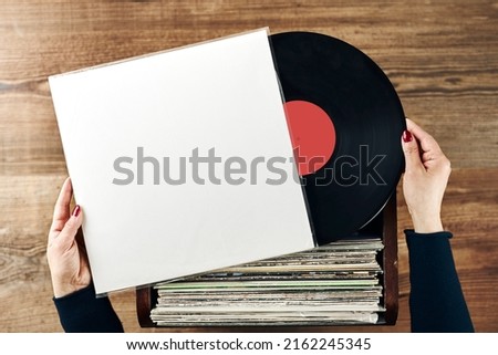 Playing vinyl records. Listening to music from vinyl record player. Retro and vintage music style. Woman holding analog LP record album. Stack of old records. Music collection. Music passion Royalty-Free Stock Photo #2162245345
