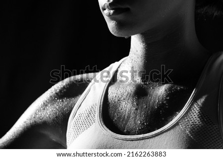Asian Tan Skin Sport Girl in Fitness Bra, exercise sweat water drop in low key exposure lighting. black background, shoulder part, concept woman can do Royalty-Free Stock Photo #2162263883