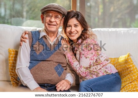 Portrait of beautiful Latin woman hugging her older father smiling and looking at camera. Royalty-Free Stock Photo #2162276707