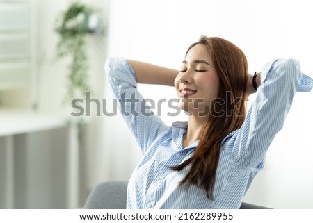 Happy asian woman Relaxing Sitting On Sofa At Home, work from home concept.