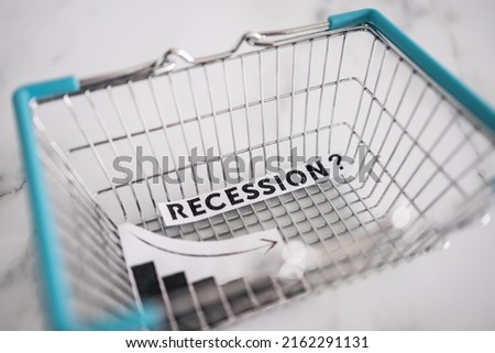 recession and stagnating economy conceptual image with text inside of shopping basket with graphs showing stats going down Royalty-Free Stock Photo #2162291131