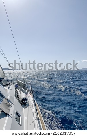 Sailboat in Aegean sea. Sailing on yacht. Yachting sport in the morning. Yacht sailing in an open sea. Close-up view from the deck to the bow and sails. selective focus Royalty-Free Stock Photo #2162319337