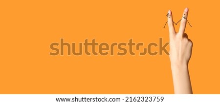 Human fingers with drawings of happy couple on orange background with space for text
