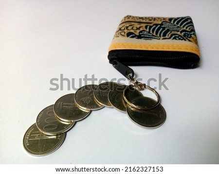 some Indonesian coins Rp. 1000 came out of the wallet, in the photo on May 31, 2022 in Surakarta, Central Java, Indonesia, with a plain white background.