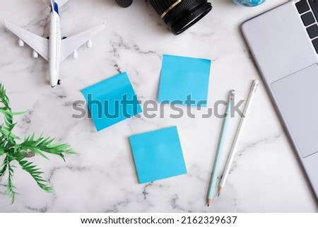 Travel flat lay composition with laptop, camera, airplane and note paper. Buy online ticket concept.