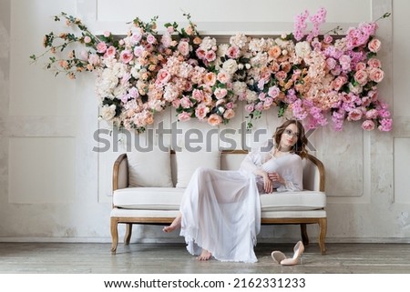 Woman in white boudoir dress in light floral interior