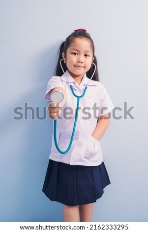 Happy cute girls in white medical uniform and stethoscope act like doctor. child dreams of becoming a doctor career concept.