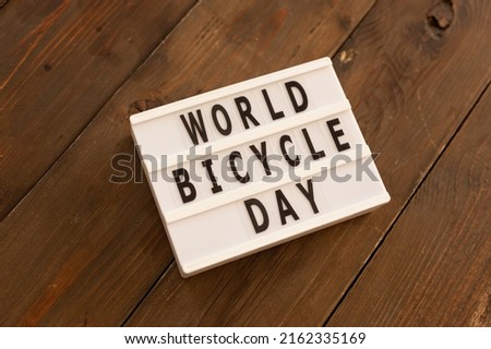 Toy bicycle and lightbox with text World bicycle day, environment protection, sustainable lifestyle concept.