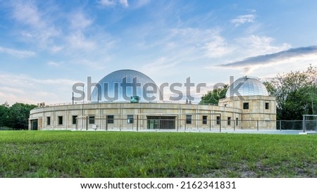 Silesian planetarium after renovation. The dome of the Silesian planetarium shining in the light of the setting sun. Aluminum panels on the roof . Royalty-Free Stock Photo #2162341831