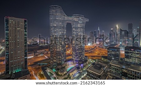 Panorama showing futuristic Dubai Downtown and finansial district skyline aerial night timelapse. Many illuminated towers and skyscrapers with traffic on streets