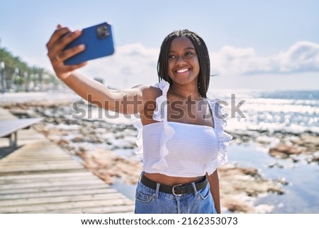 Young african american girl smiling happy make selfie by the smartphone at the beach.