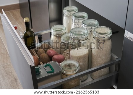 Variety of flours, rices, potatoes, onion, garlic, olive oil, vinegar in kitchen drawer. Zero waste storage concept. Royalty-Free Stock Photo #2162365183