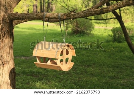 Wooden feeder on a tree