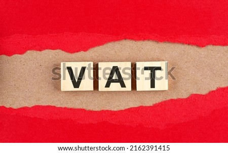 Vat word on wooden cubes on a red torn paper , financial concept background