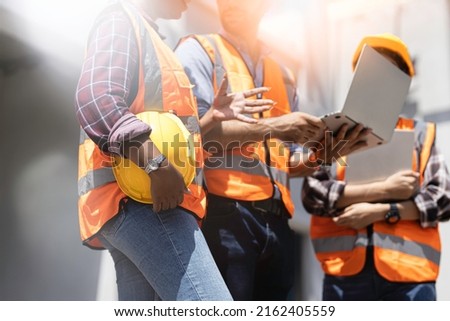Three experts inspect commercial building construction sites, industrial buildings real estate projects with civil engineers, investors use laptops in background home, concrete formwork framing. Royalty-Free Stock Photo #2162405559