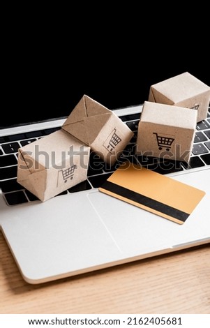 Credit card and packages on laptop with blank screen