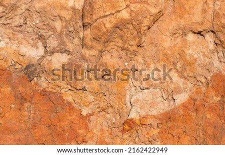 Sedimentary rocks with a high content of iron oxide. Red soil, loam. The texture of the soil. Royalty-Free Stock Photo #2162422949