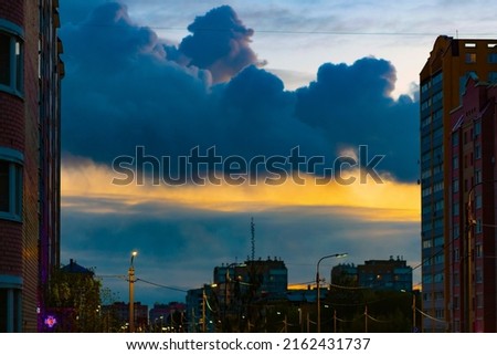 A large cumulonimbus cloud over the city in the evening at sunset. Picture for weather forecast. Selective focus. Copy space for the text above.