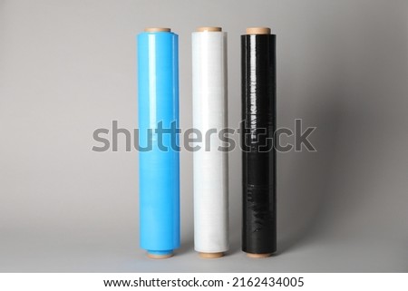 Rolls of different stretch wrap on light grey background