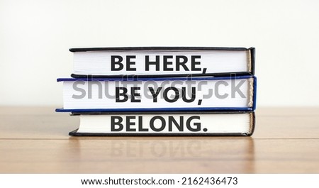 Diversity, inclusion and belong symbol. Books with words 'be here, be you, belong' on beautiful wooden table, white background. Business, diversity, inclusion and belong concept. Copy space.