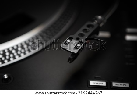 Turntables needle cartridge in closeup. Professional DJ turn table player for vinyl records. Curated collection of royalty free music photos and images for wallpaper design on shutter stock