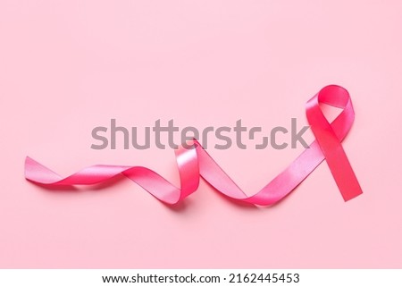 Top view of pink ribbon symbol breast cancer awareness with space for text over pink background