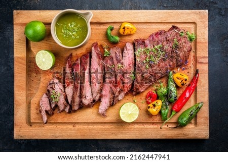 Modern design barbecue dry aged wagyu bavette de flanchet steak with chili and chimichurri sauce as top view on a wooden cutting board  Royalty-Free Stock Photo #2162447941
