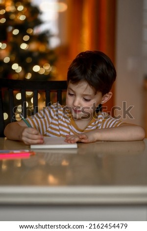 a five-year-old boy learns to draw remotely. the boy draws a drawing with colored pencils