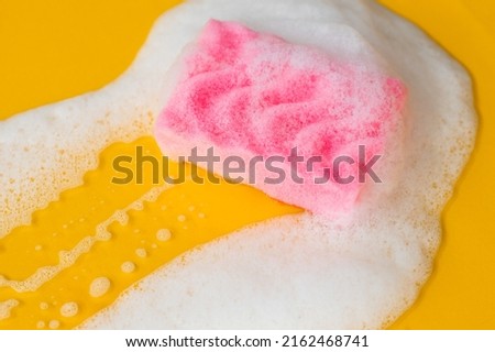 Pink sponge in foam on a yellow background