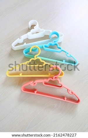Colored plastic Clothes Hangers on wooden background