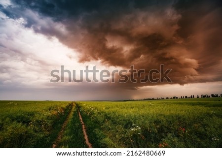 Dark ominous clouds in front of a hurricane over farmland. Adverse weather conditions. Location place agricultural region of Ukraine, Europe. Wallpaper force of nature. Discover the beauty of earth.